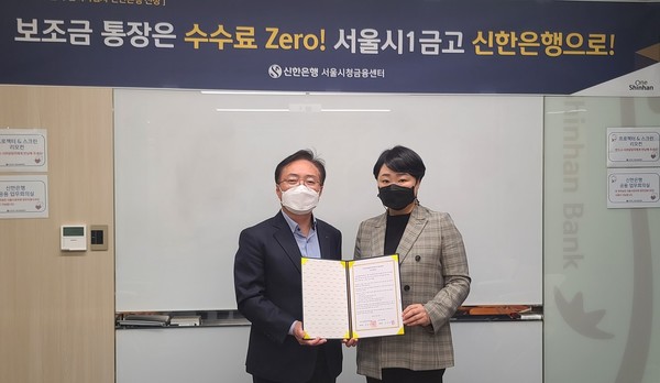 서울시청년활동지원센터와 신한은행이  업무협약을 체결하고 협약서를 펼쳐보이고 있다.