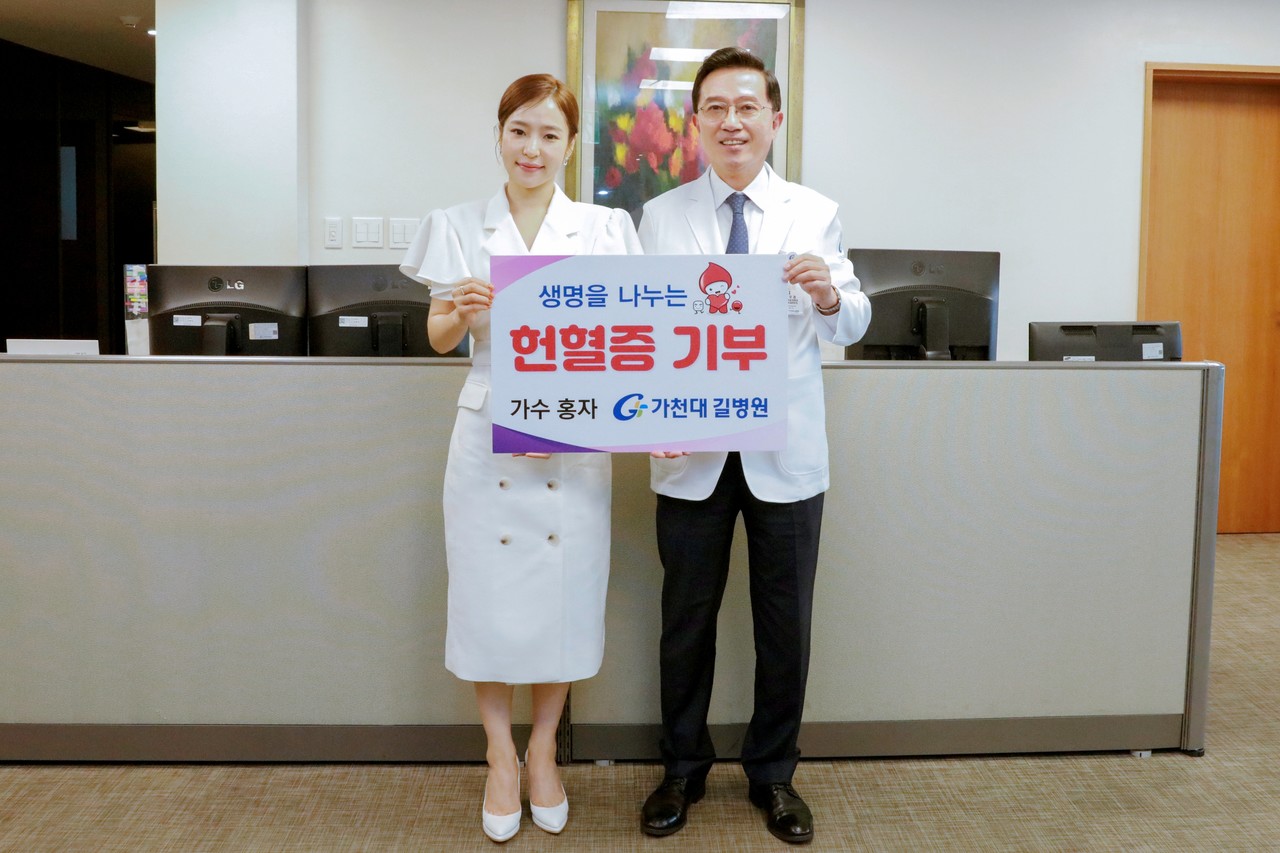 헌혈증 기부 기념촬영을 하고 있는 가수 홍자(왼쪽)과 김우경 병원장(오른쪽)