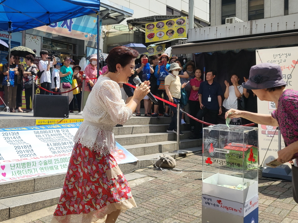 [사진설명] 한 시민이 가수 김용임의 공연을 보고 ‘사랑더하기’ 모금에 참여하고 있다.