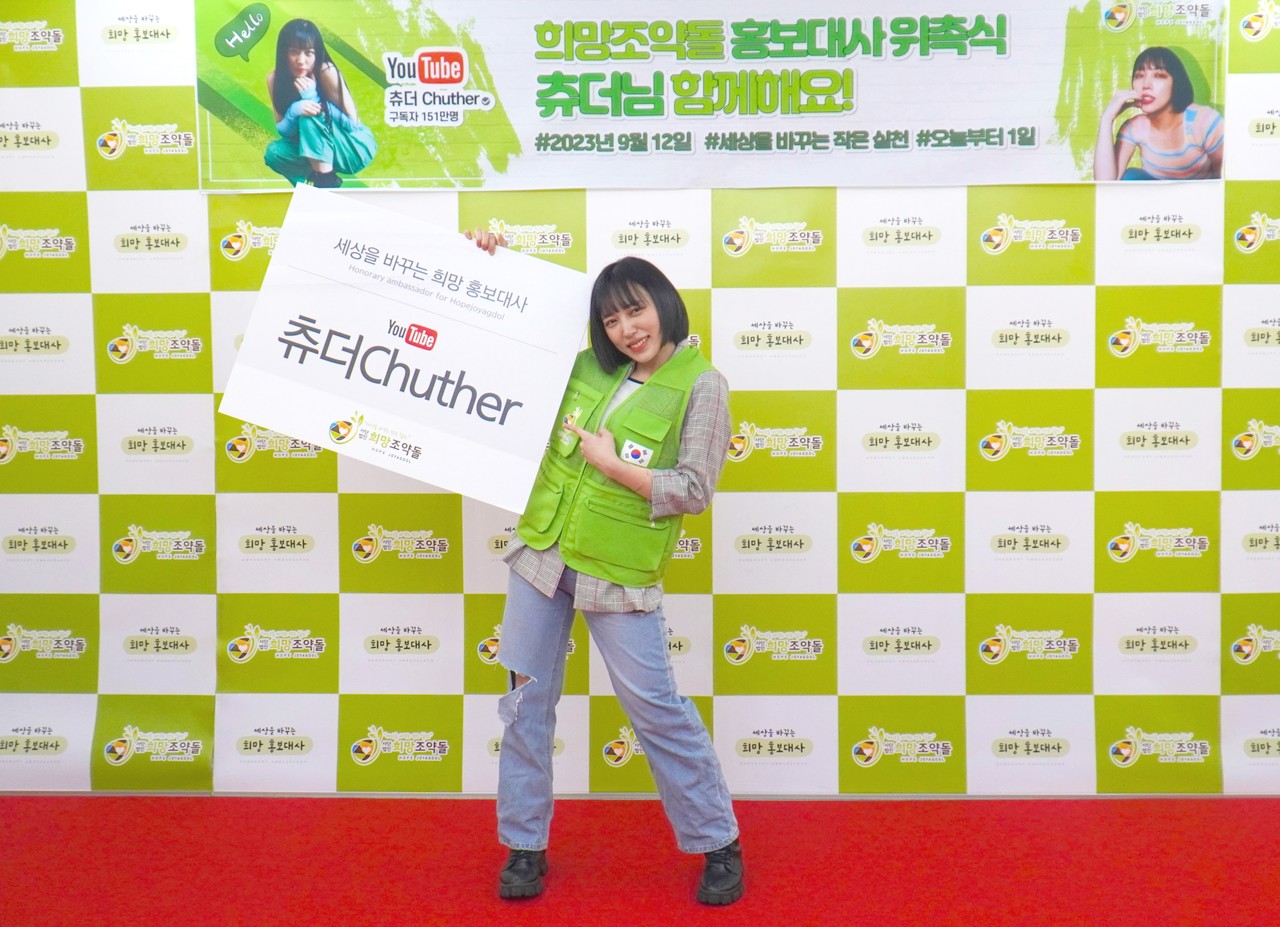 ▲사진: 유튜버 츄더가 희망조약돌 포토월 앞에서 기념포즈를 취하고 있다.  출처: 희망조약돌