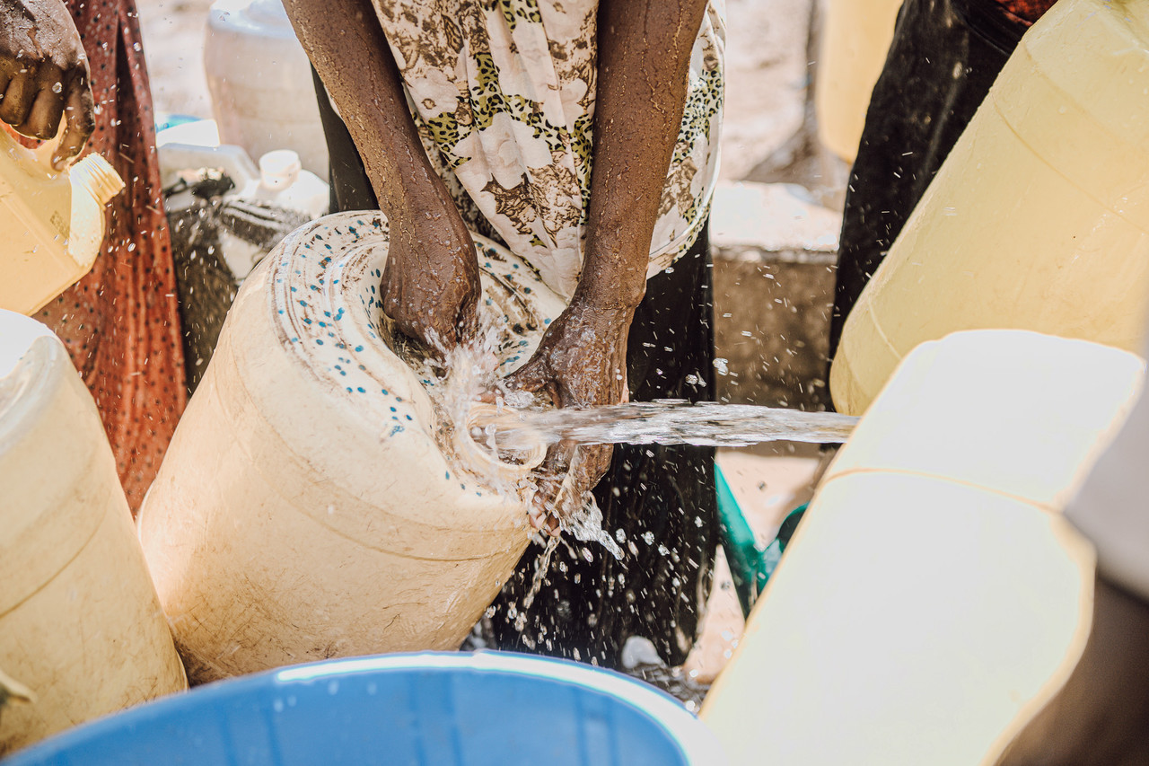 ▲사진: 2024년 씨에스윈드의 후원금으로 식수를 지원받은 난민캠프 주민들이 깨끗한 물을 제리캔에 담고 있다. 출처: 팀앤팀