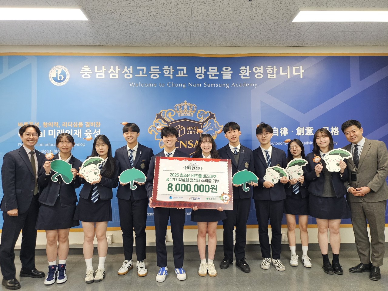 ▲사진: 충남삼성고 학생들이 ‘2025 청소년 비즈쿨 비즈마켓·제12대 학생회 청성제’를 통해 마련한 수익금 800만 원을 초록우산에 기부한 뒤 기념촬영을 하고 있다.(맨 왼쪽부터 김우현 초록우산 충남지역본부장, 왼쪽에서 다섯 번째 박재범 학생회장, 여섯 번째 채서윤 학생회 부회장, 맨 오른쪽 이대석 충남삼성고 교사) / 출처: 초록우산 충남지역본부)